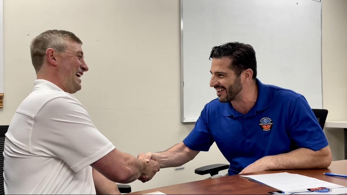 Phil DePaul shakes hands with a business partner.